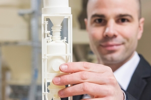  2 ISS-Sales Director Robert Partzsch with a 3D-Print of the projected conveying system 