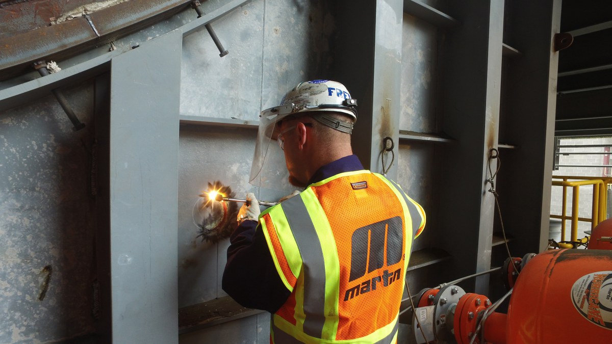 Technicians drill through the outer wall, then weld the Core Gate in place