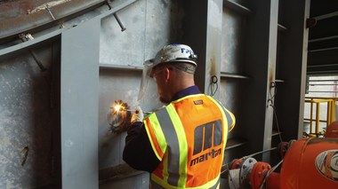 Technicians drill through the outer wall, then weld the Core Gate in place