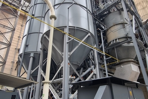  2 The new test facility rises 24 m into the air. The raw material is stored in the silo tower in the foreground and the finished product in the silo at the back left 