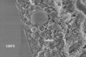  	NanoSEM (HV: 2 kV), M2-Bruchfläche, Alter 7 d, Wasserlagerung: Bindemittelmatrix zwischen HÜS-Korn und angelöstem OPC-Klinkerkorn 