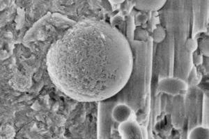  18	UHPC matrix with spherical shaped silica fume particles – uncoated sample imaged in LV-SEM mode at 2 kV: a direct comparison of a progressing pozzolanic reaction [a) Silica fume particle with signs of dissolution, b) respectively in its original state] 