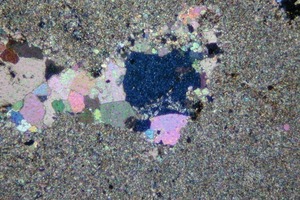  	Mikrogefüge des Trias-Kalksteins mit großen Calcit-Kristallen im Zentrum und Mikrit 