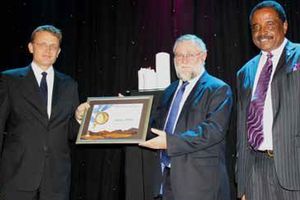 1 Hans-Wilhelm Schuette, receiving the NMA Manufacturer of the Year Award from Hon Calle Schlettwein, Minister of Trade & Industry and Brian Black, Chairperson of the NMA. The company also won the NMA Most Environmentally Friendly Manufacturer Award for 2013