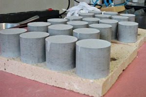 1 Compacted raw meals on a Mg-Spinel plate (left) and breaking of clinker after burning (right)