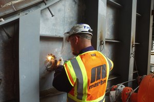 Technicians drill through the outer wall, then weld the Core Gate in place